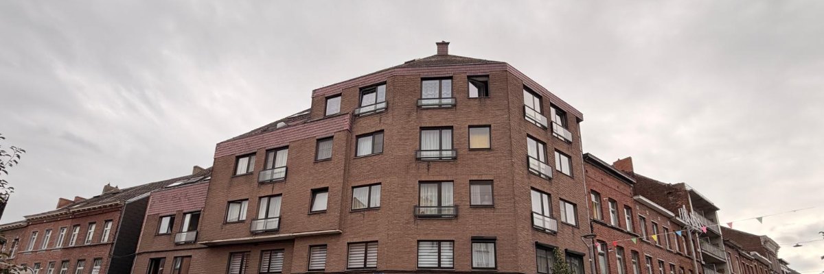 Immeuble à appartements en briques, à l'angle de deux rues, avec ses balcons