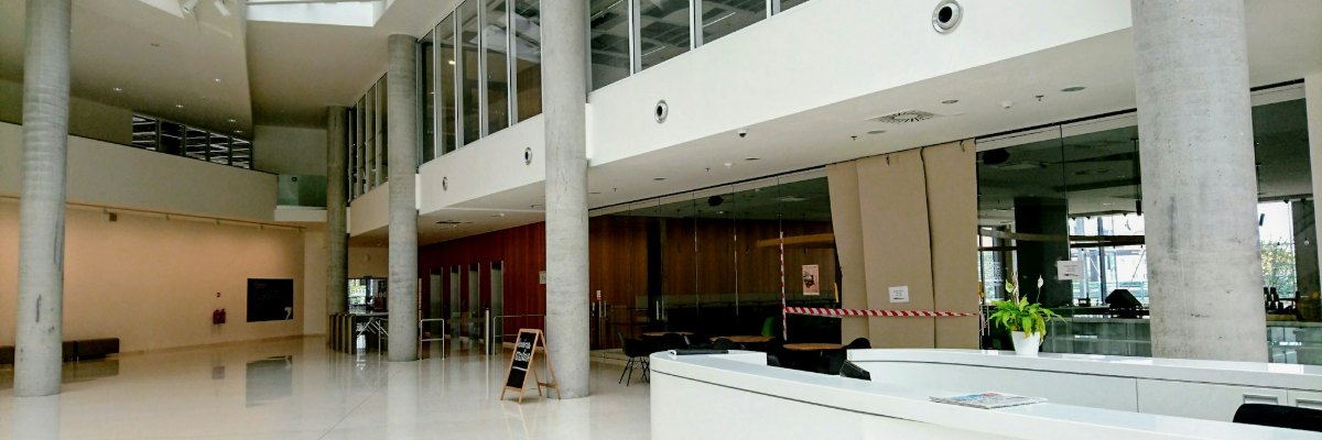 Hall d'entrée d'un immeuble de bureaux, colonnes en béton et mezzanine vitrée